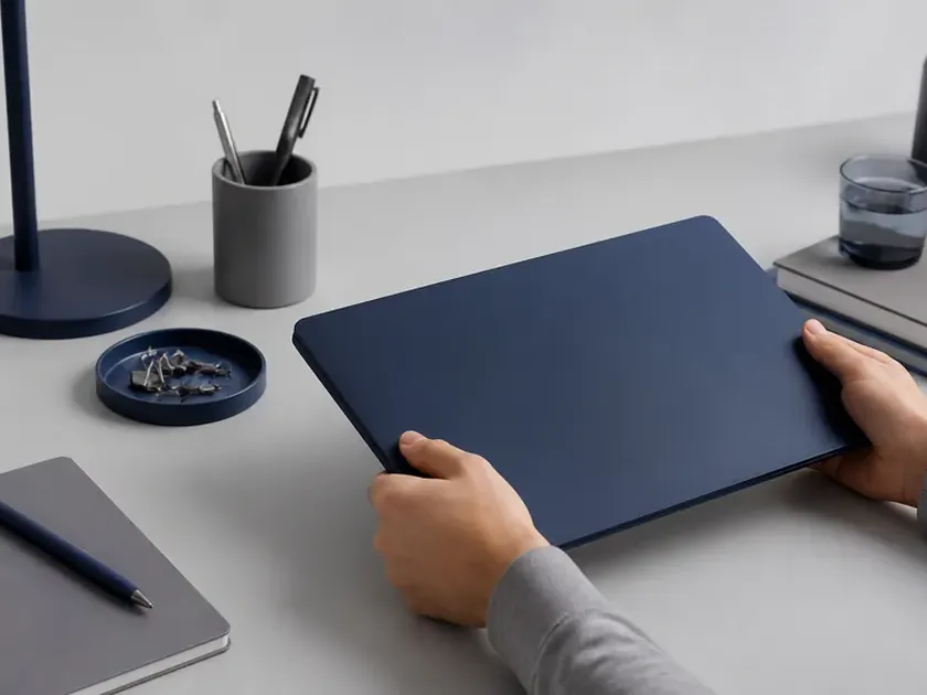 Several distinct closed laptops arranged in a row on a table, each a different colour